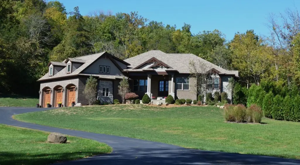 A large modern house with a garage and green lawn.